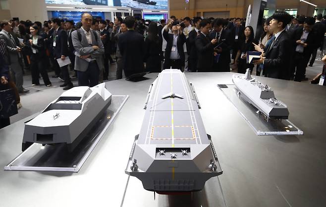 지난달 28일 부산 해운대구 벡스코 제1전시장에서 열린 2025 국제해양방위산업전(MADEX)에서 참가자들이 HD현대중공업 부스를 찾아 미래형 무인전력모함 등을 살펴보고 있다. 부산=뉴스1