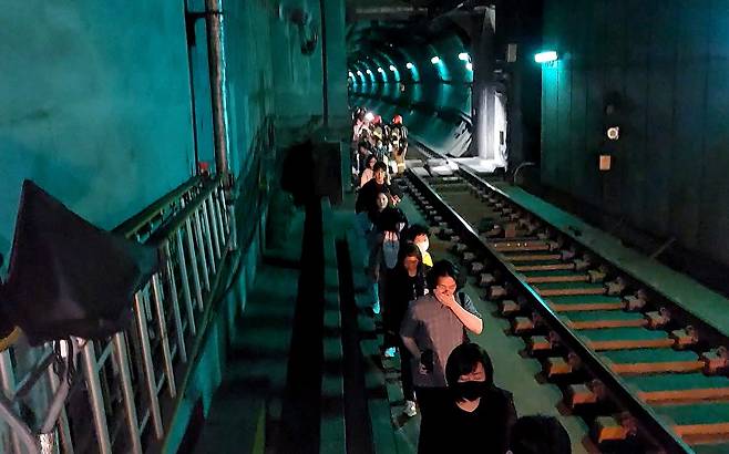 31일 오전 서울 지하철 5호선 마포역~여의나루역 구간을 지나는 열차에서 방화로 인한 화재가 발생, 승객들이 선로를 통해 대피하고 있다. 영등포소방서 제공.