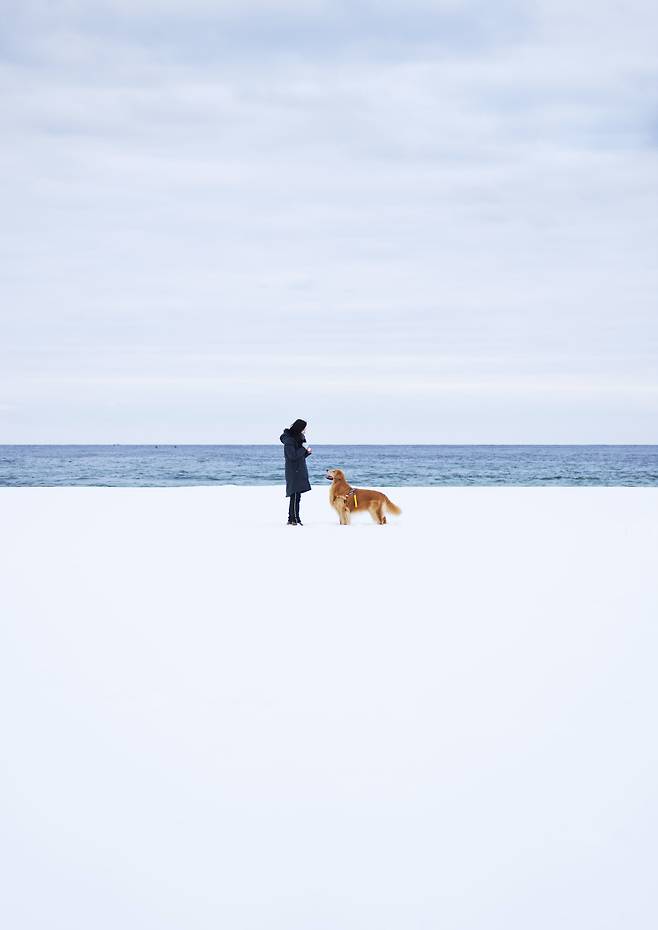 2024년 2월 강원도 고성 송지호 해변에서 폭설이 내린 후 해변이 흰 눈에 쌓여 사진가 아내 문정희 씨와 마누가 서로 바라보고 있다. / 사진가 김원범