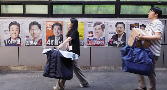 제21대 대통령선거 사전투표 둘째 날인 30일 서울 중구 소공동주민센터에 마련된 사전투표소에서 사전투표사무원들이 관내 사전투표함과 관외 사전투표지를 이송하고 있다. 연합뉴스