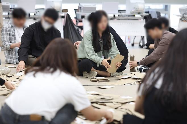 제21대 대통령선거 사전투표 둘째 날인 30일 서울 중구 을지누리센터에 마련된 사전투표소에서 사전투표사무원들이 참관인 및 공정선거참관단이 지켜보는 가운데 관외투표함을 열어 투표용지 분류 작업을 하고 있다. /사진=연합뉴스
