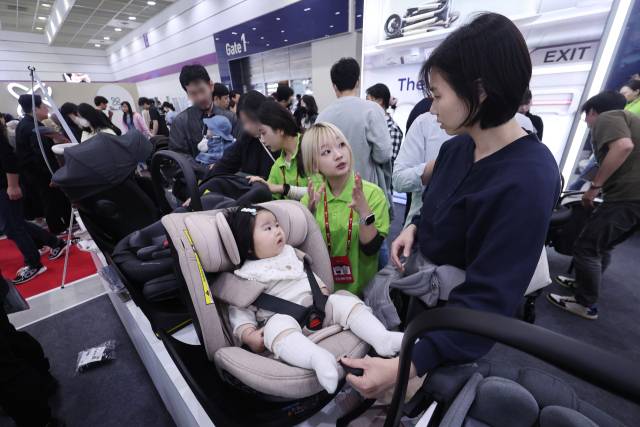 서울 강남구 코엑스에서 열린 2025 코베 베이비페어에서 한 아기가 카시트에 앉아보고 있다. 연합뉴스