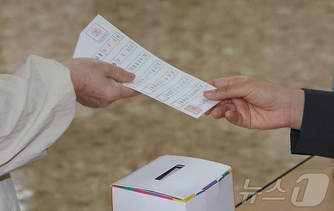 제21대 대통령 선거 투표일인 3일 서울 강남구 국민연금공단 서울남부지역본부에 마련된 투표소에서 유권자가 투표용지를 받고 있다. 2025.6.3/뉴스1 ⓒ News1 허경 기자