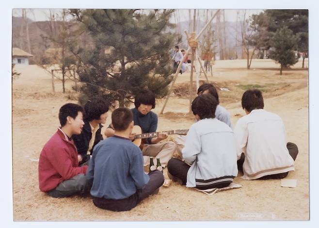 1979년 시계 만드는 오리엔트 공장에 다닐 때 남이섬으로 야유회를 가서 둥글게 앉아 노래하는 모습.(왼쪽에서 첫번째)(더불어민주당 제공)