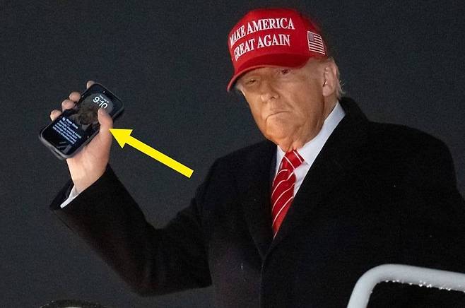 도널드 트럼프 미국 대통령이 지난달 30일 대통령전용기(에어포스원)에서 내리며 취재진을 향해 손을 흔들고 있다. 손에 들고 있는 휴대전화 잠금화면에 트럼프 본인의 얼굴 사진이 보인다. /X