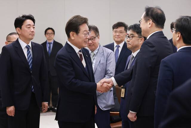 이재명 대통령이 4일 서울 용산 대통령실 청사에서 열린 \'대통령 1호 명령, 비상경제점검 태스크포스(TF) 회의\'에 참석하며 정인교 산업통상자원부 통상교섭본부장과 인사하고 있다. 연합뉴스