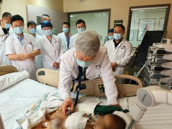 서울아산병원 간이식·간담도외과 이승규 석좌교수가 중국 칭화대 부속 창궁병원에서 생체 간이식 수술을 받은 생후 6개월 리웨이(가명)의 상태를 살펴보고 있다. 사진 서울아산병원