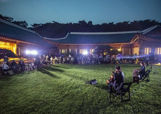 지난 2022년 7월 19일 서울 청와대에서 열린 '청와대, 한여름 밤의 산책' 언론 공개 행사 참가자들이 관저에서 펼쳐지는 퓨전 국악 공연을 관람하고 있다. 청와대 야간 개방 프로그램의 일부였다. 중앙포토