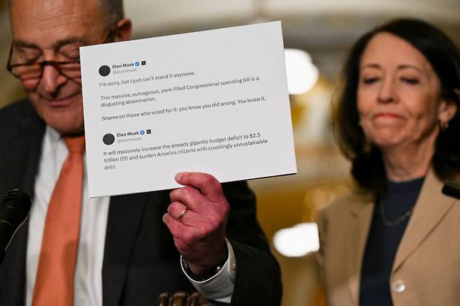 척 슈머 미국 상원 민주당 원내대표가 3일(현지시간) 워싱턴 연방의회 의사당에서 일론 머스크가 엑스에 올린 감세법안 비판 글을 들어보이고 있다. 로이터연합뉴스