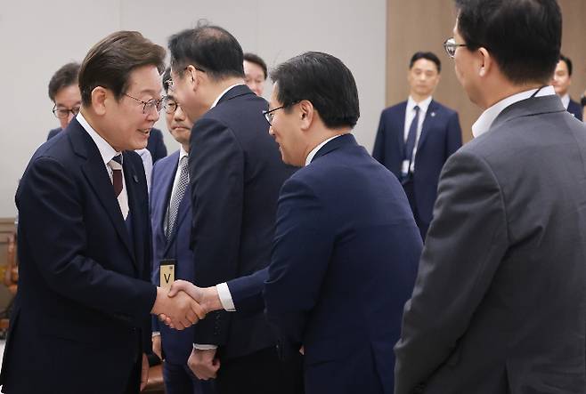 이재명 대통령이 4일 서울 용산 대통령실 청사에서 열린 '대통령 1호 명령, 비상경제점검 태스크포스(TF) 회의'에 참석하며 김범석 기획재정부 장관 직무대행 1차관과 인사하고 있다. 연합뉴스