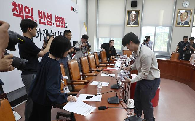 국민의힘 관계자들이 5일 오전 국회에서 열리기로 예정된 비상대책위원회의가 언론에 비공개임을 공지하며 회의자료를 치우자 취재진이 빈자리 등을 취재하고 있다. 윤운식 선임기자 yws@hani.co.kr