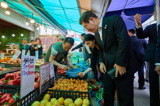이재명 대통령과 김혜경 여사가 6일 서울 동작구 남성시장을 방문해 과일을 고르고 있다. 〈사진=대통령실 제공〉