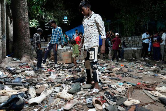 11명이 숨진 압사 사고가 발생한 인도 카르나타카주 벵갈루루 치나스와미 경기장 앞에 시민들이 대피하며 잃어버린 신발이 놓여 있다. 벵갈루루=AP 연합뉴스