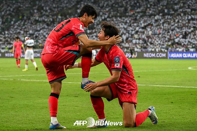 축구대표팀 공격수 오현규(오른쪽)가 6일(한국시간) 이라크와의 2026 국제축구연맹(FIFA) 북중미 월드컵 아시아 3차 예선에서 득점을 터뜨린 뒤 어시스트해준 전세진의 축구화를 닦아주는 세리머니를 하고 있다. /AFPBBNews=뉴스1