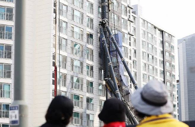6일 경기도 용인시 기흥구 서천동 인덕원~동탄 복선전철 공사 현장에서 중장비인 천공기(지반을 뚫는 건설기계)가 넘어져 인근 아파트 건물 벽면에 기댄 모습으로 쓰러져 있다.(사진=연합뉴스