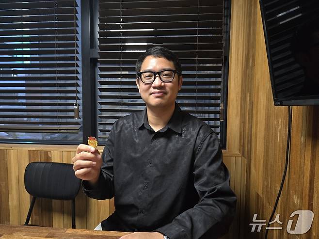 5일 서울 서초구의 한 스터디카페에서 뉴스1과 인터뷰를 하고 있는 김충신 씨. 탈북민으로부터 선물 받은 '혁명 배지'를 소개하고 있다.ⓒ News1