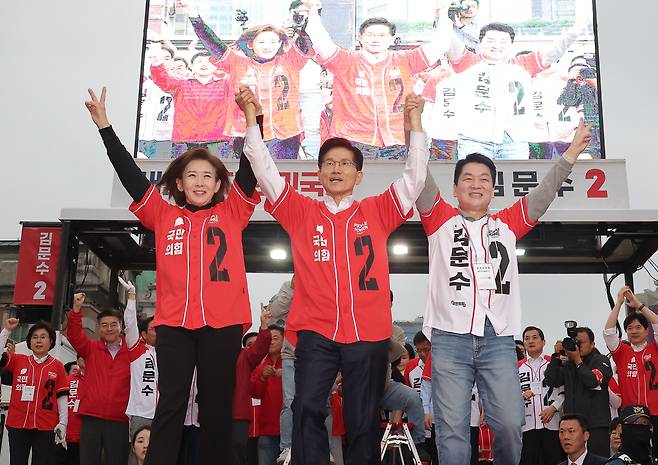 국민의힘 김문수(가운데) 전 대선 후보가 지난달 19일 서울 중구 서울역 광장에서 나경원(왼쪽)·안철수 의원의 손을 맞잡고 유세를 하고 있다. /뉴스1