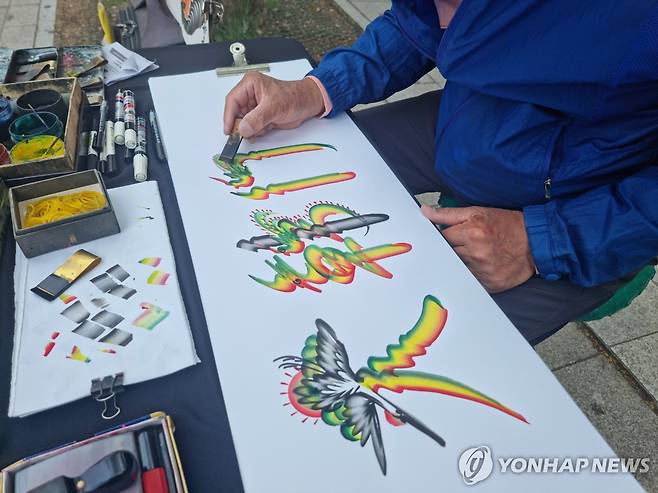 혁필화 할아버지 (서울=연합뉴스) 서윤호 인턴기자 = 지난달 26일 오후 시청역 앞에서 '혁필화 할아버지' 이종욱(87) 씨가 혁필로 '대한국민'을 쓰고 있다. 2025.6.8
