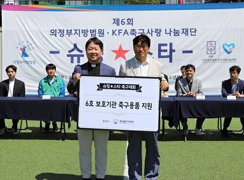 자생의료재단 신민식 사회공헌위원장(오른쪽)과 효광원 시설장 김현 신부가 2025 슈팅스타 대회에서 축구용품 전달식을 갖고 있다(제공=자생한방병원)
