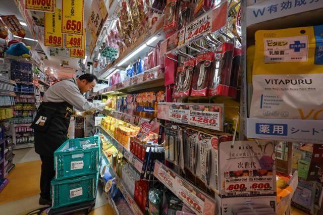 일본 대형 수퍼마켓 돈키호테 직원이 4월 21일 도쿄 시부야 지점에서 매대에 물건을 진열하고 있다. 도쿄=AFP 연합뉴스