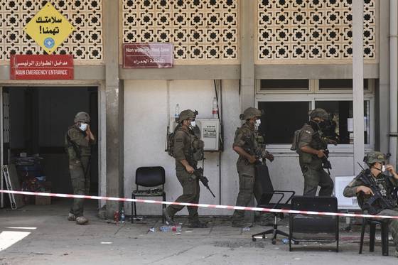 8일(현지시간) 이스라엘 군인들이 가자지구 칸유니스에 있는 유럽병원 앞을 지나가고 있다. AP=연합뉴스