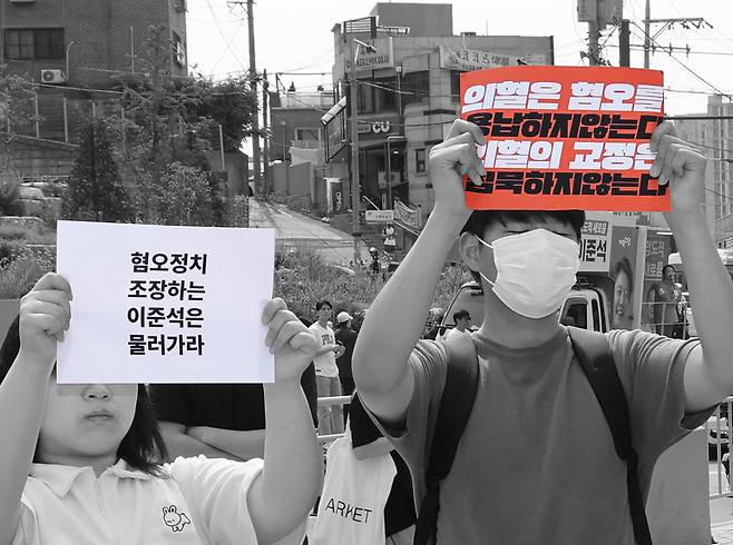 이준석 개혁신당 대선 후보가 지난달 30일 서울 동작구 중앙대학교에서 유세 중인 가운데 일부 학생들이 최근 이 후보의 TV토론 여성 신체 관련 발언을 규탄하며 팻말을 들고 있다. 정지윤 선임기자