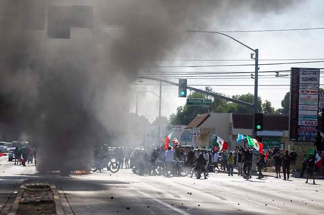 현지 시각 8일 오전 LA 남쪽 콤프턴 지역에서 시위대와 당국이 충돌하는 모습 (사진=연합뉴스)