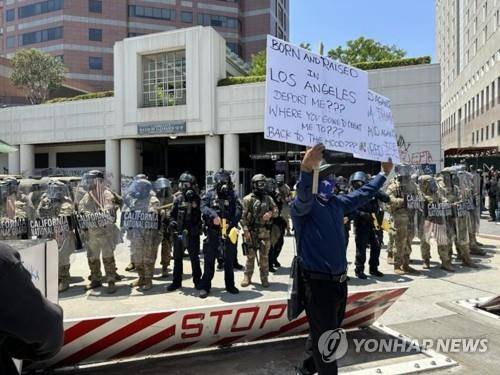 미 LA에서 불법이민 단속에 항의하는 시위대와 이를 막아선 주방위군 (로스앤젤레스=연합뉴스) 임미나 특파원 = 8일(현지시간) 미국 로스앤젤레스(LA) 도심의 연방 구금시설인 '메트로폴리탄 디텐션 센터'(Metropolitan Detention Center) 앞에서 주방위군이 시위대와 대치하고 있다. 시위대는 미 이민세관단속국(ICE)의 대대적인 불법 이민자 단속에 반발하는 시위를 사흘째 벌이고 있다. 2025.6.9