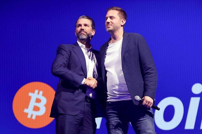 트럼프 대통령의 맏아들 도널드 트럼프 주니어(왼쪽)가 지난달 27일 네바다주 라스베이거스의 베니션(베네치아) 라스베이거스에서 열린 비트코인 콘퍼런스에서 럼블의 크리스 파블로프스키와 악수를 나누고 있다. AFP 연합뉴스