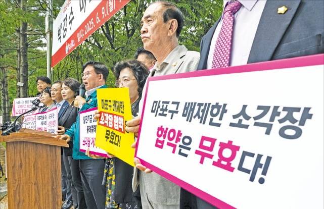 9일 서울 상암동 마포자원회수시설 앞에서 박강수 마포구청장과 손팻말을 든 주민들이 소각장 공동 이용 협약 개정 철회 및 추가 설치 반대 기자회견을 하고 있다. 뉴스1