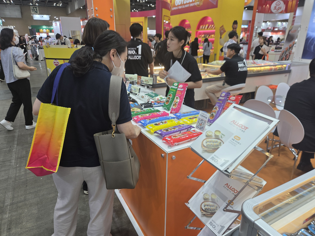 식품기업 부스로 구성된 킨텍스 제1전시장 국내관에서 한 관람객이 냉동김밥 제품을 보고 있다.