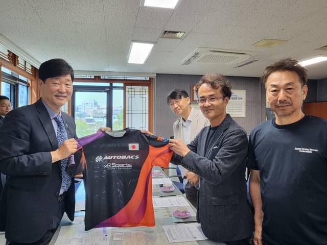 윤동욱 전주 부시장(왼쪽)과 일본드론축구연맹 나카자키 히로유키 회장이 일본 국가대표 유니폼을 들고 기념촬영을 하고 있다. /전주시