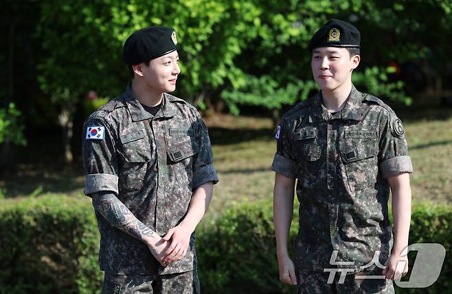 방탄소년단(BTS)의 정국과 지민(오른쪽)이 11일 오전 경기도 연천군 연천공설운동장에서 군복무를 마친 뒤 수줍은 미소를 짓고 있다. ⓒ News1 권현진 기자