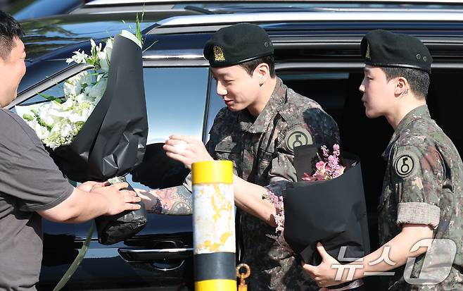 방탄소년단(BTS)의 정국 지민(오른쪽)이 전역 인사를 위해 11일 오전 경기도 연천군 연천공설운동장에 도착해 꽃다발을 선물 받고 있다. ⓒ News1 권현진 기자