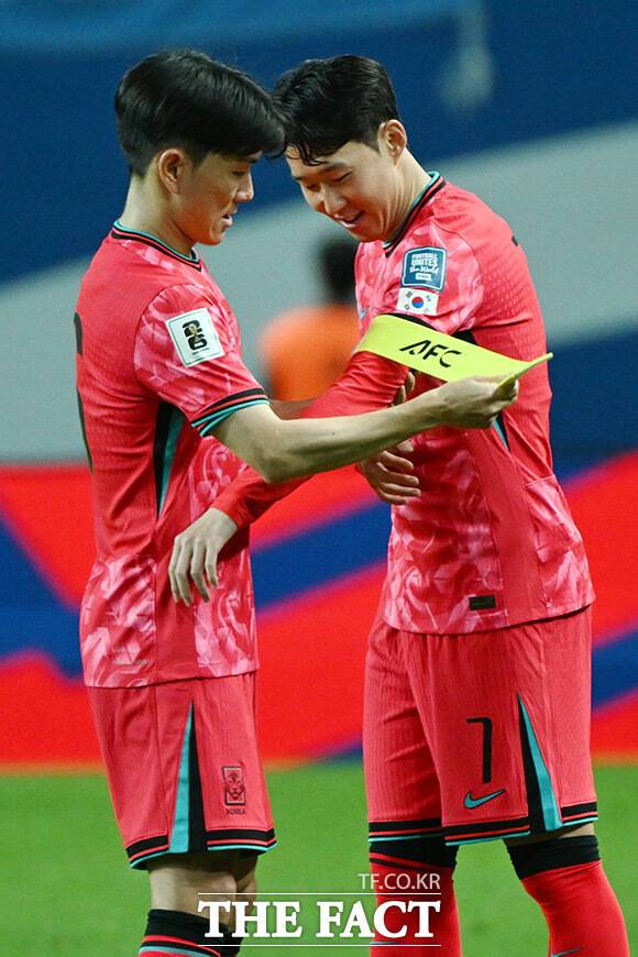 손흥민(오른쪽)에게 주장 완장 전달하는 황인범.