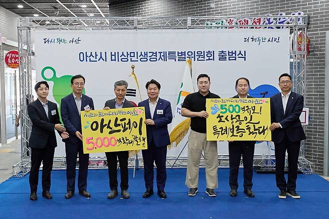 오세현 아산시장(가운데)과 참석자들이 지난 10일 열린 비상민생경제특별위원회 출범식에서 아산페이 확대 발행 및 소상공인 특례보증 확대 문구를 새긴 팻말을 들고 기념 사진을 찍고 있다. 아산시 제공