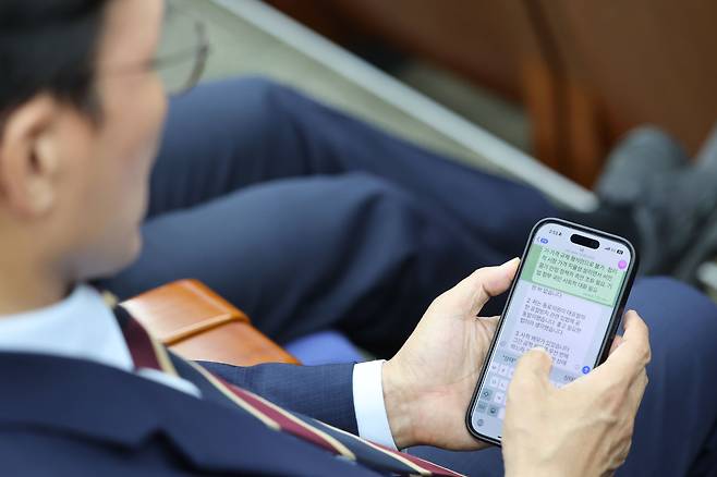 김민석 국무총리 후보자가 13일 오후 서울 여의도 국회에서 열린 더불어민주당 원내대표 선출을 위한 의원총회에 참석해 자신의 신상과 관련해 제기된 의혹들에 답하는 글을 작성하고 있다. 김 후보자는 이 글을 이날 오후 자신의 페이스북에 올렸다. /뉴시스