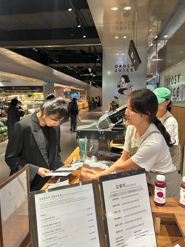 최연희 오롯이 주스 대표(오른쪽)가 5월 30일부터 6월 12일까지 롯데백화점 광주점 식품관에서 한 고객에게 구독형 착즙주스 브랜드 '오롯이 주스'를 설명하고 있다.