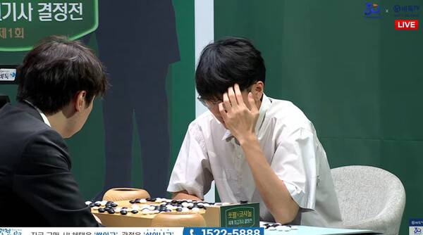 신진서 9단이 12일 서울 한국기원에서 열린 쏘팔코사놀 세계 최고기사 결정전 풀리그 마지막 경기 승리 뒤 당이페이 9단과 복기하고 있다. 바둑TV 갈무리