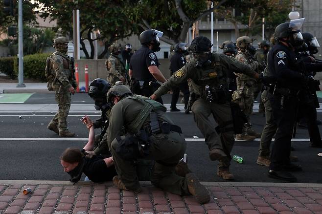 2025년 6월9일 미국 캘리포니아주 샌타애나에서 트럼프 행정부의 강압적인 이민자 단속에 항의하던 시위대가 진압경찰에 체포되고 있다. AFP 연합뉴스