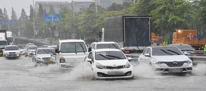 장마철에는 안전한 전기차 운행을 위해 주의사항을 숙지하는 것이 필요하다. 사진은 폭우가 쏟아진 지방의 한 도로 위를 달리는 자동차 모습. /사진=뉴시스