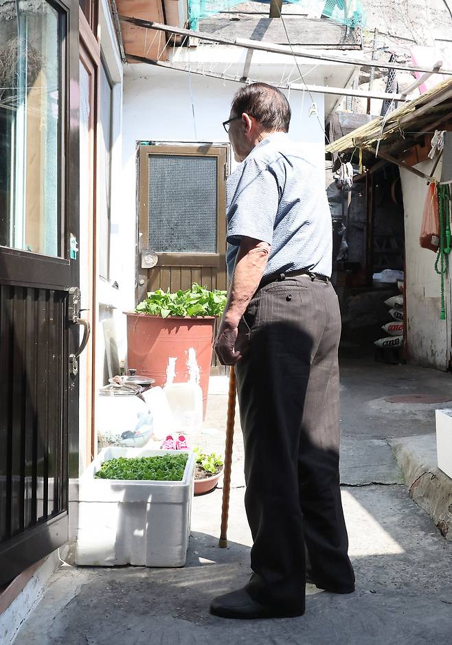 서울 서대문구 홍제동 개미마을에서 50년 이상 거주한 임경식(93)씨가 지팡이를 짚은 채 자택 대문을 바라보고 있다. 임씨는 재개발이 진행되더라도 수억원의 추가분담금이 발생해 부담이 커 어찌할지 모르겠다고 말한다. 이제원 선임기자