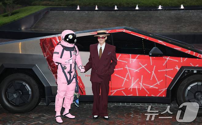 빅뱅 지드래곤(GD,권지용)이 13일 오후 서울 용산구 그랜드 하얏트 서울 호텔에서 열린 '피스마이너스원 프리미엄 하이볼 론칭 파티-더 시그널(THE SIGNAL)'에 참석해 PEACEMINUSONE 로고가 새겨진 사이버트럭 앞에서 우주인과 포즈를 취하고 있다. ⓒ News1 권현진 기자