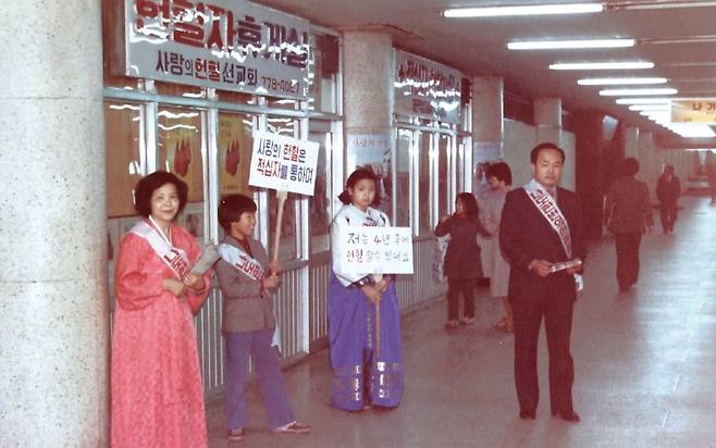 사랑의장기기증운동본부 이사장 박진탁 목사가 1980년 서울시 중구 시청 앞 지하도에 개설된 헌혈의 집 앞에서 가족들과 함께 캠페인을 펼치고 있다. 사랑의장기기증운동본부 제공