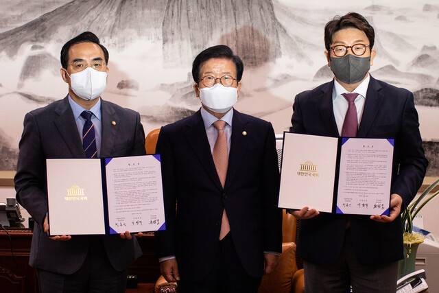 2022년 4월22일 박병석 국회의장(가운데)과 박홍근 더불어민주당(왼쪽), 권성동 국민의힘 원내대표가 국회에서 ‘검찰의 수사-기소권 분리’(검수완박) 법안과 관련한 국회의장 중재안에 합의한 뒤, 서명을 마친 합의문을 들어 보이고 있다. 공동취재사진