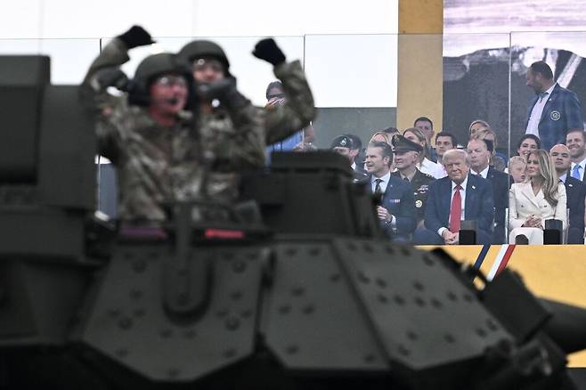 도널드 트럼프 미국 대통령의 79번째 생일이자 미 육군 창설 250주년 기념 열병식이 열린 14일(현지시각) 워싱턴 디시(D.C.) 열병식 행사장에서 탱크과 군용 차량들이 행진하는 모습을 트럼프 대통령 등이 지켜보고 있다. 워싱턴/AFP 연합뉴스