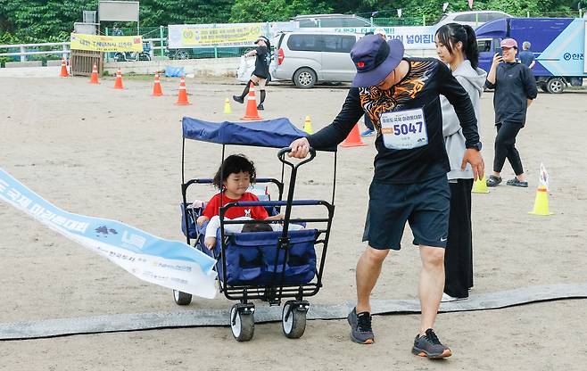 15일 경북 울릉군 울릉읍 울릉문화예술체험장에서 열린 독도지키기 제20회 울릉도 국제 마라톤대회에서 한 아버지가 유모차를 끌며 결승선을 통과하고 있다.