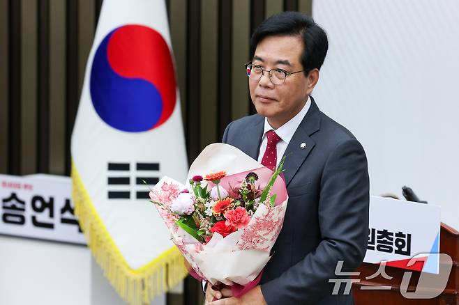 국민의힘 신임 원내대표로 선출된 송언석 의원이 16일 오후 서울 여의도 국회에서 열린 의원총회에서 꽃다발을 들고 있다. 2025.6.16/뉴스1 ⓒ News1 안은나 기자