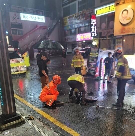 지난 14일 오전 2시 33분쯤 부산 연제구 연산동에서 소방관이 열려있는 맨홀 구멍에 안전조치를 하고 있다. /부산소방재난본부 제공