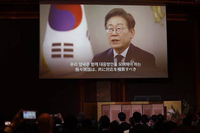 이재명 대통령이 보낸 영상 축사가 16일 서울 중구 롯데호텔에서 열린 한일 국교정상화 60주년 기념 행사에서 나오고 있다. ⓒ연합뉴스